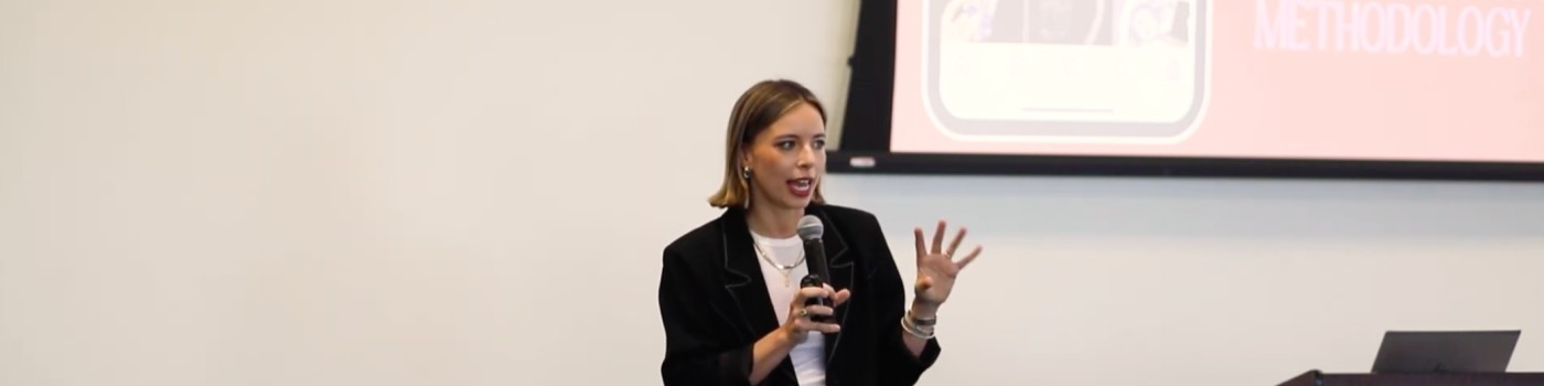 Anne Singer presenting her Growth Mastermind talk, gesturing toward the screen
